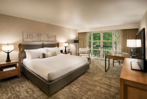 
a hotel room with a large bed and a large window at Tempe Mission Palms, a Destination by Hyatt Hotel in Tempe
