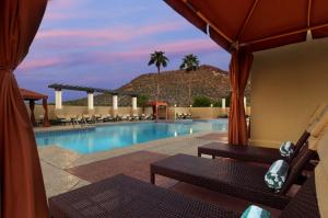 a swimming pool with chairs and a resort at Tempe Mission Palms in Tempe