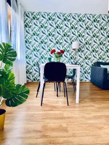 einen Tisch und einen Stuhl in einem Zimmer mit einer Tapete in der Unterkunft Legnica Apartament 42m2 Delux 4 in Legnica