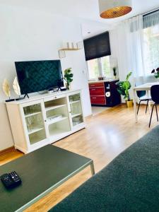 a living room with a flat screen tv on a white cabinet at Legnica Apartament 42m2 Delux 4 in Legnica