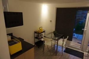 uma sala de estar com uma mesa de vidro e uma televisão em RJO Serviced Accommodation Purfleet em Purfleet