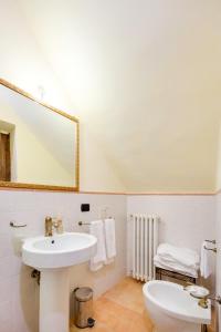 a white bathroom with a sink and a mirror at Castello Di Caccuri Suites in Caccuri