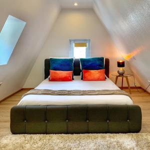 Un dormitorio con una cama con almohadas de colores. en The POINT CITY-Center - Place KLEBER, en Estrasburgo