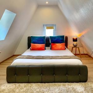 a bedroom with a bed with colorful pillows on it at The POINT CITY-Center - Place KLEBER in Strasbourg