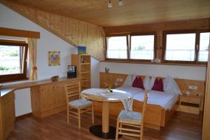 a bedroom with a bed and a table and chairs at Burggräflerhof in Lana