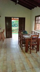 Casa de campo في بتروبوليس: غرفة طعام مع طاولة وكراسي خشبية