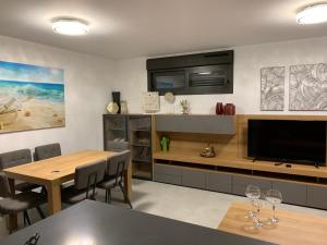 a living room with a dining table and a television at Arenal Dream The Beachfront Paradise in Jávea