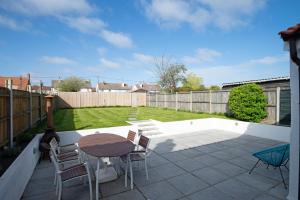 a patio with a table and chairs and a fence at Avocet House in Wells next the Sea