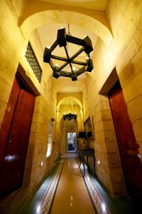 an empty hallway in a building with a chandelier at The Lodge in Cospicua