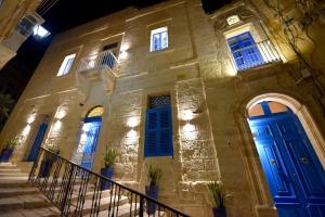 a building with blue doors on the side of it at The Lodge in Cospicua