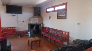 sala de estar con sofá y chimenea en Hostal El Amigo Lucho en San Pedro de Atacama