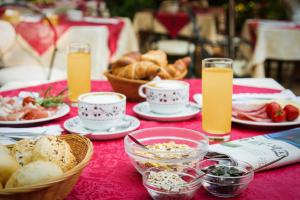 einen Tisch mit Teller mit Lebensmitteln und Gläsern Orangensaft in der Unterkunft Hotel La Meridiana in Lido di Venezia
