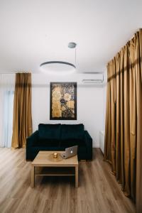 un soggiorno con divano verde e tavolo di Gaudi Accommodation a Cluj-Napoca