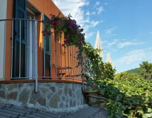 Un balcón de una casa con flores. en B&B La Costa en Pignone