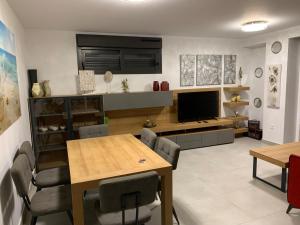 a dining room with a table and a television at Arenal Dream The Beachfront Paradise in Jávea