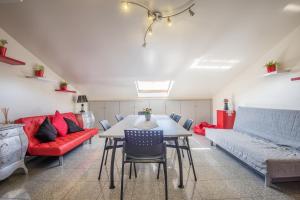a living room with a table and a red couch at Atlantic Waves Accommodation ~ Carcavelos Beach in Carcavelos