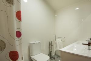 a white bathroom with a toilet and a sink at Atlantic Waves Accommodation in Carcavelos