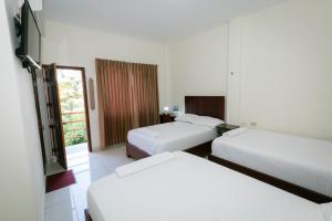Hotel Mediterraneo Inn في Santa Rosa de Lima: غرفة فندقية بسريرين ونافذة