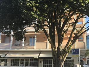 a white building with a parking sign in front of a tree at Atlantic Waves Accommodation in Carcavelos