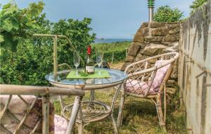 un tavolo in vetro con due sedie e una bottiglia di vino di Gorgeous Apartment In Strunjan With Kitchen a Strunjan