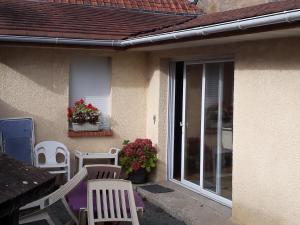 eine Terrasse mit weißen Stühlen, einem Tisch und einem Fenster in der Unterkunft charmant loft à la campagne,Hauts de France ,Somme in Rubempré