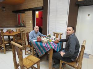 two men sitting at a table eating food at Hotel boutique urku wasi in Humahuaca