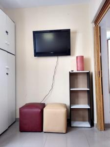 sala de estar con TV de pantalla plana en la pared en Depto de Leo frente al mar en Mar del Plata