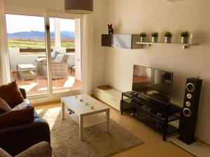 a living room with a couch and a flat screen tv at Fairway View Penthouse in Murcia