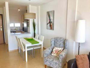 a living room with a dining room table and a chair at Fairway View Penthouse in Murcia