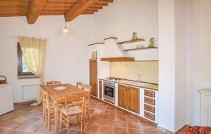 eine Küche mit einem Tisch, Stühlen und einem Tisch sowie eine Küche mit einem Herd in der Unterkunft Il Giardino degli Olivi in Castiglion Fiorentino