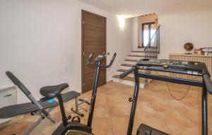 een kamer met een fitnessruimte met fitnessapparatuur en trappen bij Il Giardino degli Olivi in Castiglion Fiorentino