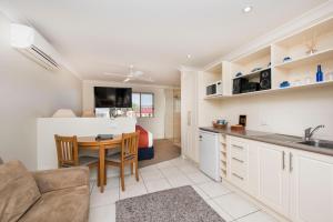 a kitchen and living room with a table and a couch at Soldiers Motel in Mudgee