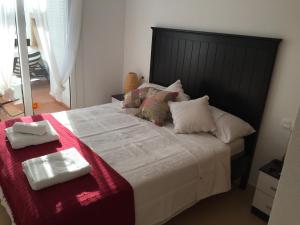 een slaapkamer met een groot bed met een rode deken bij Fairway View Penthouse in Murcia +12 foto's