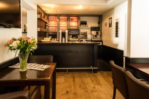 ein Esszimmer mit einem Tisch und einer Bar in der Unterkunft Hotel Restaurant Les Jumeaux in Gulpen-Wittem