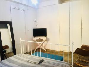 um quarto com uma cama e uma televisão na parede em Centralissimo Bologna em Bolonha
