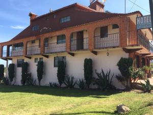 un hôtel avec un panneau devant lui dans l'établissement Hotel Lienzo Charro 1, à Huasca de Ocampo