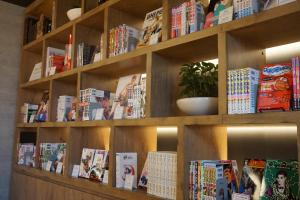 a book shelf with many books on it at MyCUBE by MYSTAYS Asakusa Kuramae in Tokyo