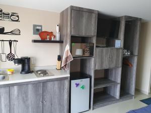 - une cuisine avec des placards en bois et un réfrigérateur blanc dans l'établissement S09 DE CASONA TRES SUITES PREMIUM INCREÍBLES ITESM CEM S09, à Mexico