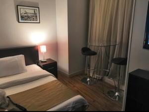 Un pat sau paturi într-o cameră la NewCity Hotel & Suites