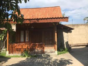 a small house with an orange tile roof at Diana's Homestay in Banyuwangi