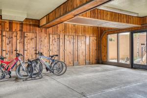 three bikes parked in a room with wooden walls at Snowfire 209B in Angel Fire