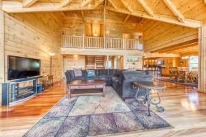 ein Wohnzimmer mit einem Sofa, einem TV und einem Tisch in der Unterkunft Majestic Lakefront Lodge in Sevierville