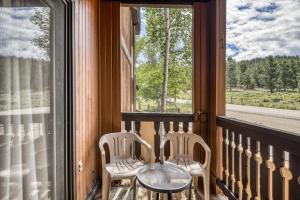two chairs and a table on a balcony with a window at Snowfire 209B in Angel Fire