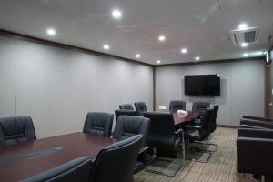 a conference room with a table and chairs and a tv at Hotel Mate Bundang in Seongnam