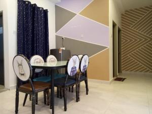 a dining room with a table and four chairs at ICOLOR HOME & STAY CH3 in Tanah Rata