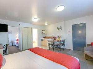 a bedroom with a bed and a kitchen with a table at Bella Vista Motel Westport in Westport