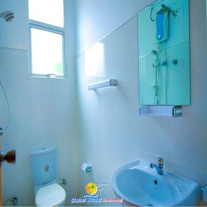 Owin Rose Yala Safari Hotel في تيساماهاراما: حمام مع حوض أزرق ومرحاض