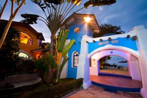 a blue and white house with a palm tree at Mantaraya Lodge in Puerto López