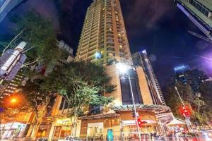 un edificio alto en una ciudad por la noche en S&P Apartments - Albert St, en Brisbane