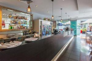 Un bar en un restaurante con un mostrador y sillas. en S&P Apartments - Albert St, en Brisbane